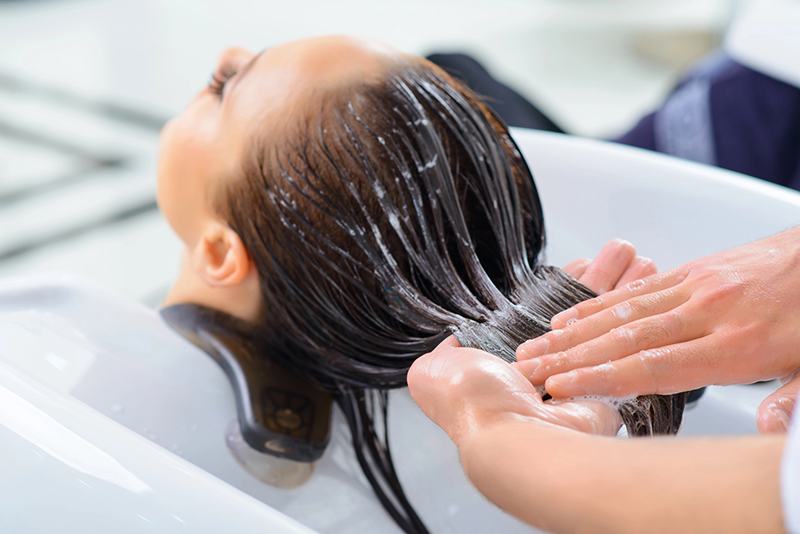 una mujer en un salon que le lavan la cabeza